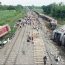 Train accident in Gonda, India. Derailed train carriages and smoke are visible.